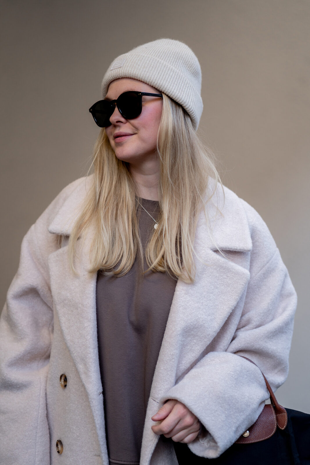 winteroutfit wollmantel beige sonnenbrille beanie
